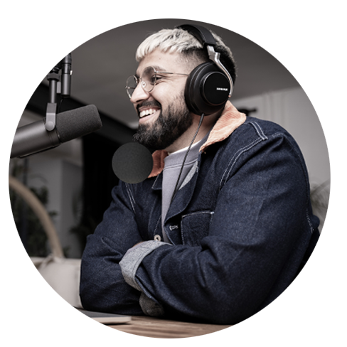 Man smiling in front of microphone with headphones on demonstrating the effectiveness of enterprise podcasting.